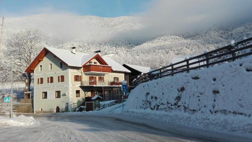 a house on the side of a snow covered road at Zum Lindenwirt - Al Tiglio in Naz-Sciaves