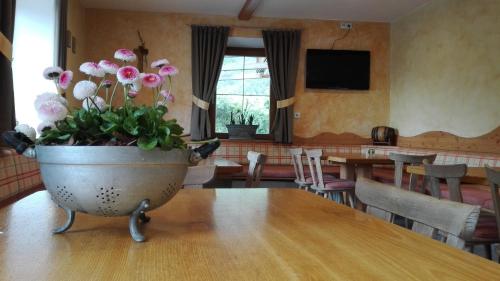 a vase of flowers sitting on a table in a room at Zum Lindenwirt - Al Tiglio in Naz-Sciaves