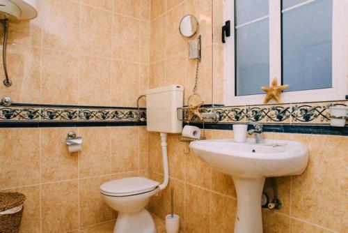 a bathroom with a toilet and a sink and a window at Casa Pasinovic in Kotor