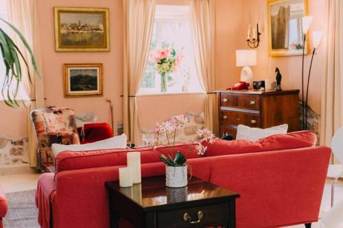 a living room with a red couch and a table at Casa Pasinovic in Kotor