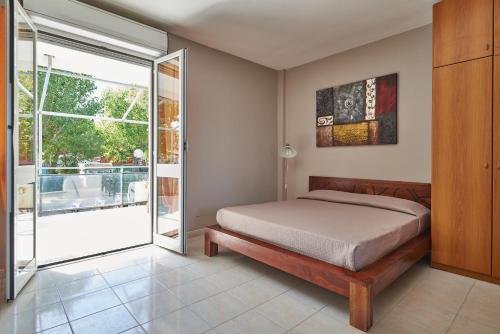 1 dormitorio con 1 cama y puerta corredera de cristal en Piccolo Paradiso, en Albenga