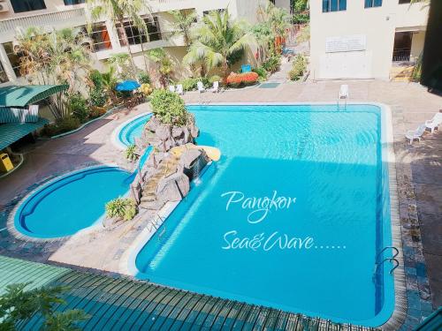 - une piscine avec un panneau indiquant le complexe dans l'établissement Sea & Wave #1 Coral Bay Apartment, à Île de Pangkor