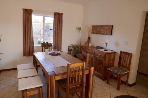 ein Esszimmer mit einem Holztisch und Stühlen in der Unterkunft Kokowit in Clanwilliam