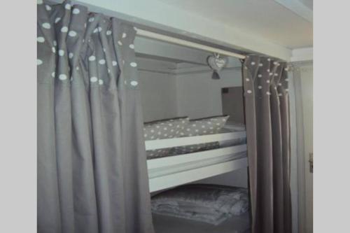 una camera con letto a baldacchino con tende grigie di Gîte Ste Cécile plage a Camiers