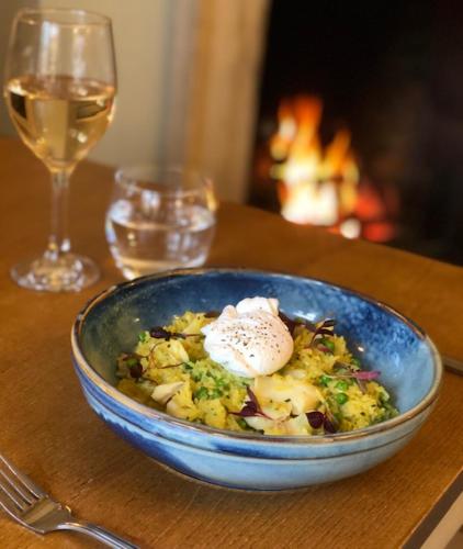 a bowl of food on a table with a glass of wine at The Admiral Hornblower in Oakham
