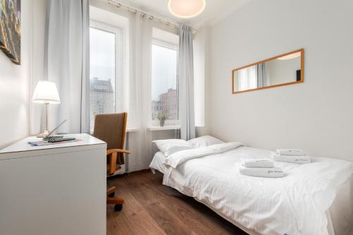 ワルシャワにあるApartament Chmielna by Your Freedomの白いベッドルーム(ベッド1台、デスク、窓付)
