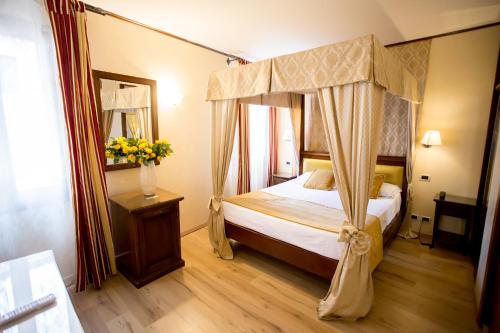 a bedroom with a canopy bed and a wooden floor at Residenza Rivo Alto in Venice
