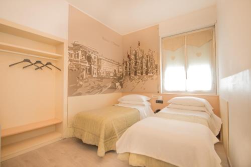 two beds in a room with a window at Hotel Astoria Gallarate in Gallarate