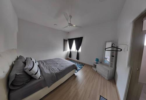 1 dormitorio con 1 cama y ventilador de techo en Chombies Muslim Homestay, en Tanah Rata