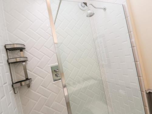 a shower with a glass door in a bathroom at Nana's Cottage in Camborne