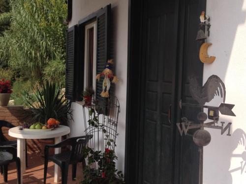 eine Veranda mit einer schwarzen Tür und einem Tisch mit einem Tisch in der Unterkunft Alba Raimondo House in Santa Vittoria dʼAlba