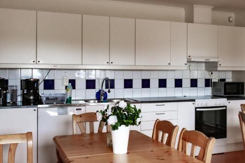 a kitchen with a table with a vase of flowers on it at Rödlix Vandrarhem & Camping in Tvååker