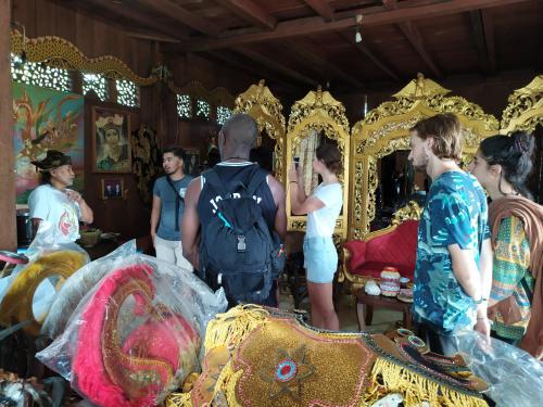 een groep mensen die rond een gouden draaimolen staan bij Griya Backpacker Pak yon in Malang