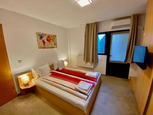a bedroom with a bed and a television in it at Cristi's Rooms - Pensiune in Oradea