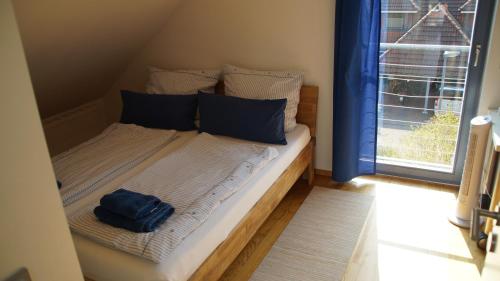 een klein bed in een kamer met een raam bij Gästehaus/FeWos/Boardinghaus Lüneburg Süd in Lüneburg