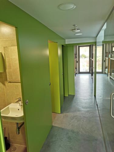 a bathroom with green and yellow walls and a sink at Los Tres Abetos in Arzúa