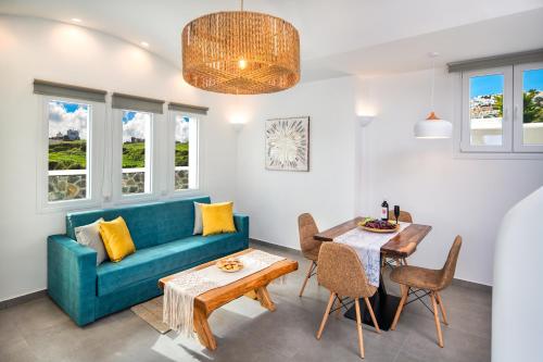 a living room with a blue couch and a table at Abasa Suites in Fira