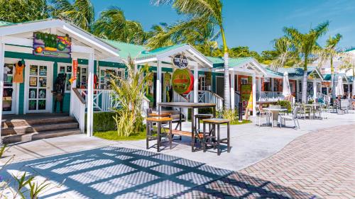 a row of shops with tables and chairs on a street at La Placita Inn in West Bay