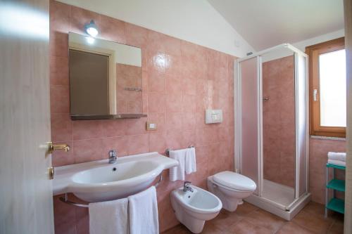 Un baño con lavabo, inodoro y ducha. en Rey beach Club, en Monte Nai