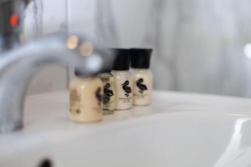 three bottles of soap sitting on a bathroom sink at Violetta in Birżebbuġa