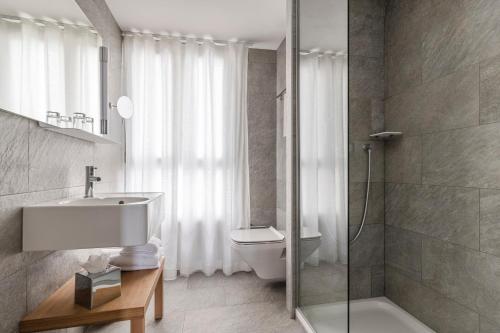 a bathroom with a toilet, sink and tub at 9Hotel Republique in Paris