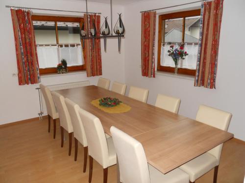 comedor con mesa de madera y sillas blancas en Appartementhaus Angelika, en Stumm