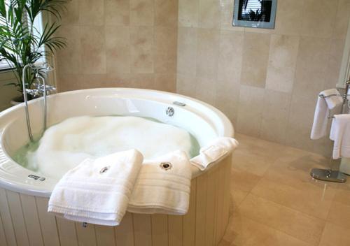 a bathroom with a bath tub with towels on it at Lough Rynn Castle in Mohill