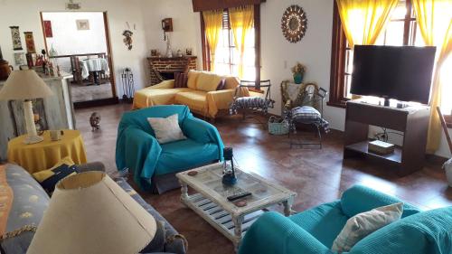 a living room with blue furniture and a tv at Posada de la Villa in Villa Gesell