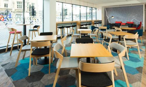 a cafeteria with tables and chairs and windows at Holiday Inn Express Bristol City Centre by IHG in Bristol