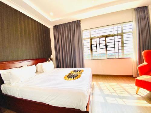 a hotel room with a bed and a red chair at Long Bao Chau Hotel in Thu Dau Mot