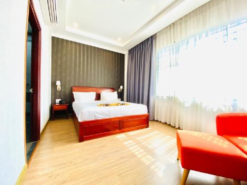 a bedroom with a bed and a large window at Long Bao Chau Hotel in Thu Dau Mot