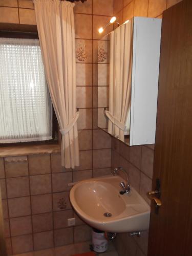 a small bathroom with a sink and a window at Ferienwohnung Haus Weitblick in Medebach