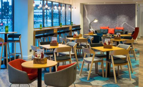 a seating area with tables and chairs in a restaurant at Holiday Inn Express Bristol City Centre, an IHG Hotel in Bristol
