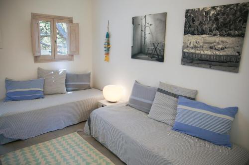 a bedroom with two beds with blue pillows and a window at La Hacienda in Sant Ferran de Ses Roques