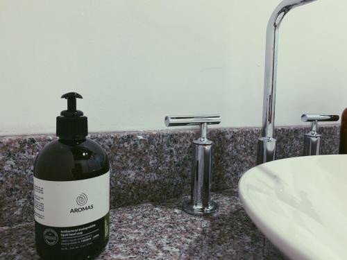 a bottle of mouthwash sitting on a counter next to a sink at Hacienda Escondida 10min to Airport in Alajuela City