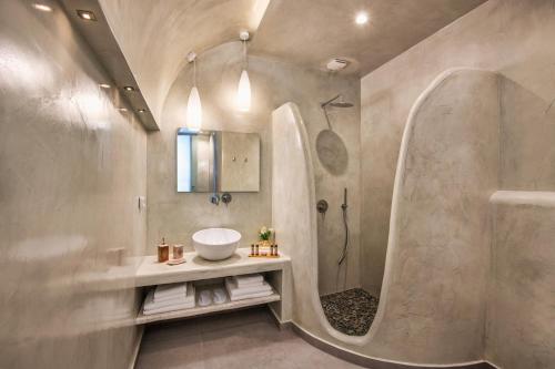 a bathroom with a sink and a shower at Abasa Suites in Fira