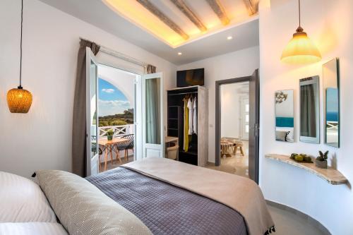 a bedroom with a bed and a view of the ocean at Abasa Suites in Fira