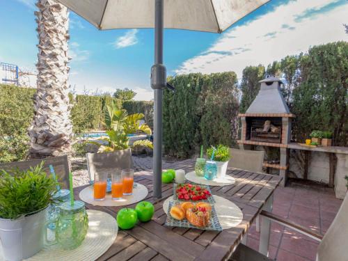 una mesa con fruta y zumo en un patio en Holiday Home Miramar by Interhome, en Riumar