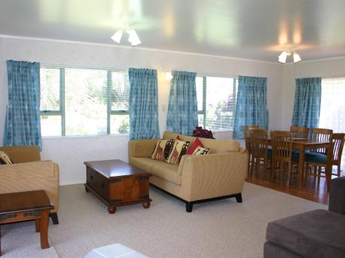 una sala de estar con un sofá y una mesa en Waihi Getaway - Waihi Beach Holiday Home, en Waihi Beach