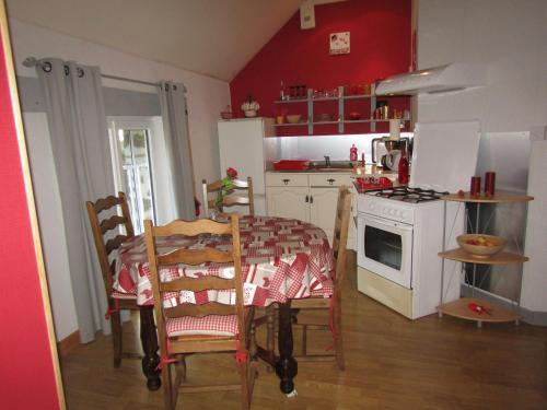 a kitchen with a table and a white stove top oven at Fermette dans les pays de la Loire in Izé