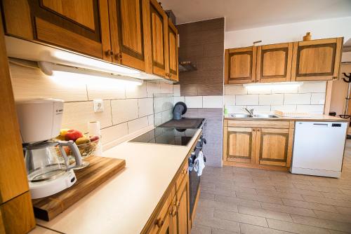 Una cocina con gabinetes de madera y un refrigerador blanco. en Valley View Holiday Home with Sauna Mrak, en Slap ob Idrijci