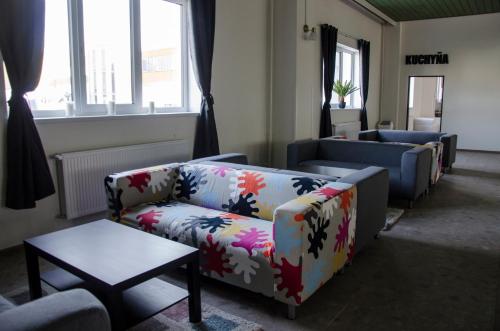 a living room with couches and a table and windows at Ubytovňa Milex in Nové Mesto nad Váhom