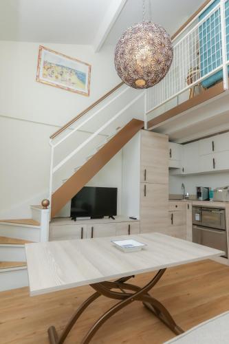 un salon avec une table et un escalier dans l'établissement Apartment Mezzanine Monte Carlo, Saint Roman Varavilla, à Roquebrune-Cap-Martin