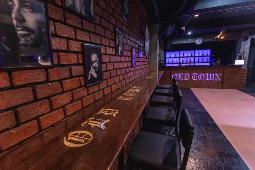 a brick wall in a bar with a counter and chairs at Old Town in Jomtien Beach