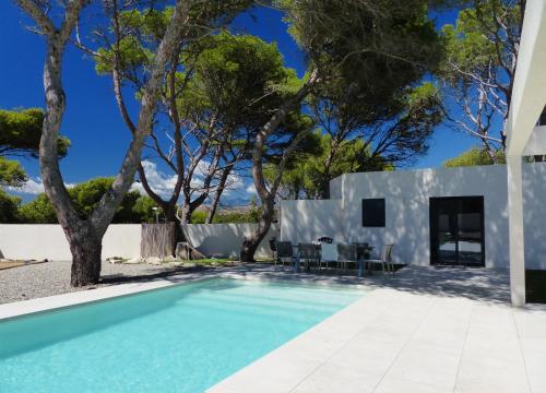 une piscine devant une maison avec des arbres dans l'établissement Villa Laricio, à Bonifacio