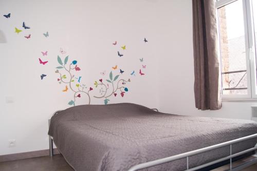 - une chambre avec un lit aux papillons sur le mur dans l'établissement Appart 2-4 pers Berck-Plage Hyper-centre, à Berck-sur-Mer