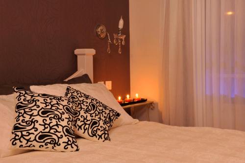 a bedroom with a bed with two pillows and candles at לה פאצה - בריכה פרטית in Had Nes