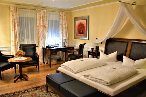 a bedroom with a bed and a desk and a table at Die Kronacher Stadthotels in Kronach