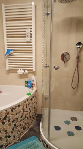 a bathroom with a shower and a tub and a sink at Südländische Flair in Neubiberg