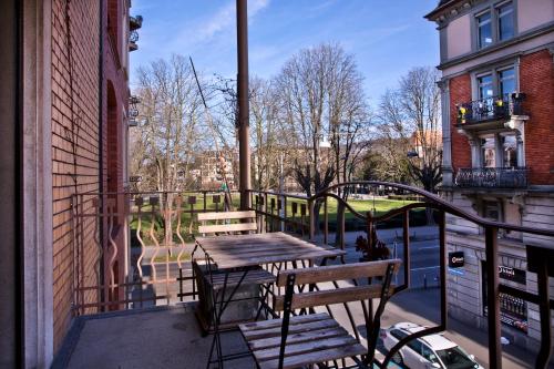 - un balcon avec une table en bois et des bancs dans un bâtiment dans l'établissement Guesthouse fürDich, à Zurich